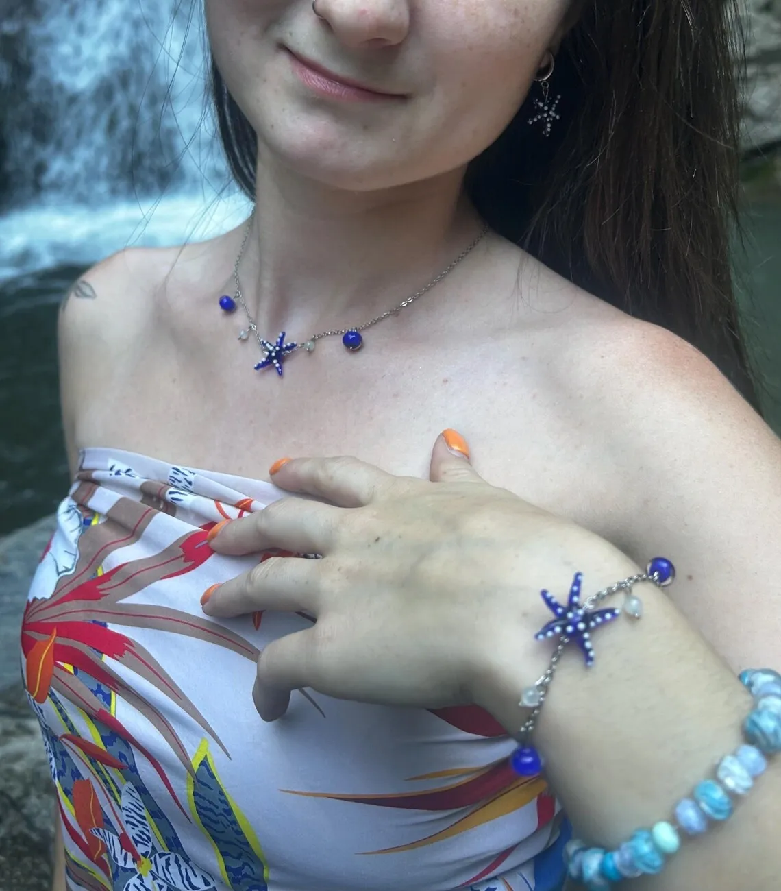 Bracelet chaîne avec motif étoile de mer bleue en verre porté au poignet
