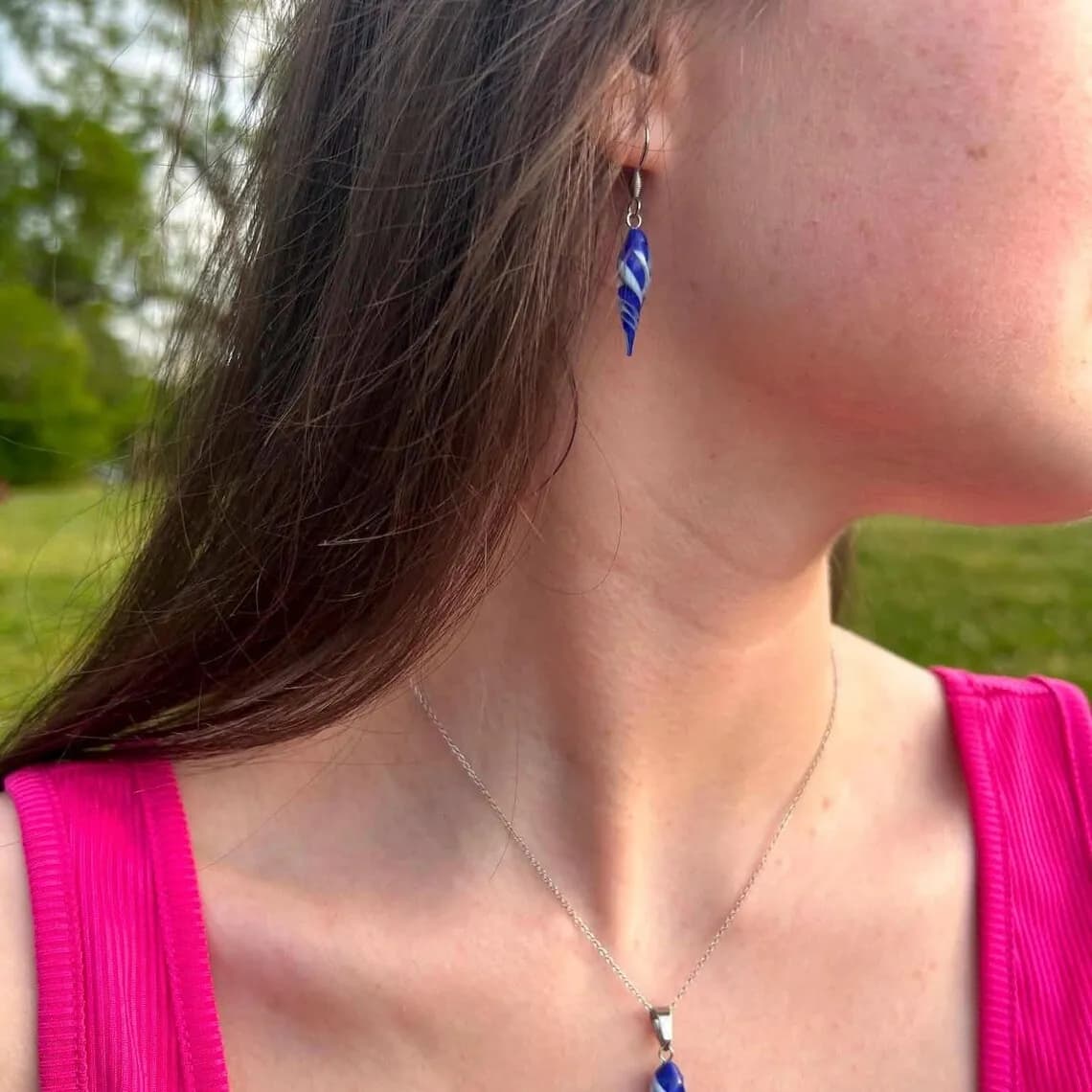Boucle d'oreille pendante bleue et blanche torsadée portée à l'oreille